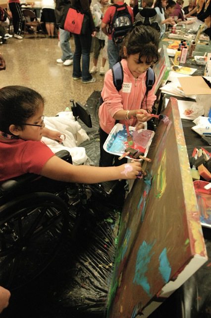 Two special needs girls painting a large canvas