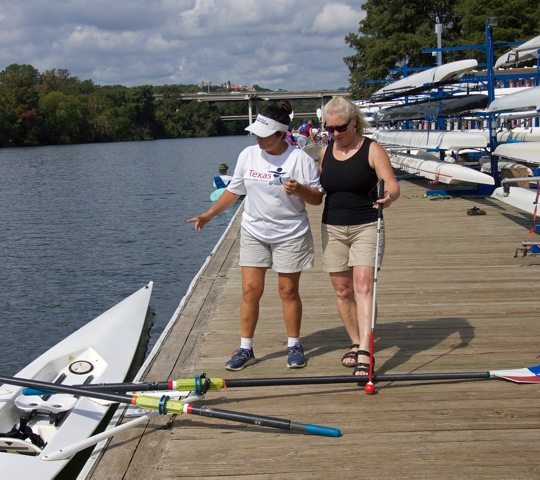 Woman leading a blind woman along the dock